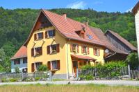 una casa amarilla con techo rojo en Gîte du Grand Pré, en Metzeral