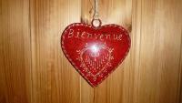 a red heart hanging on a wall with the words between us at Le Lièvre Blanc, appartement N°2 in Les Contamines-Montjoie