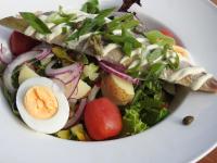 a salad with an egg on a white plate at Café Brasserie Het Heerenhuis in Het Kalf
