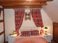 a bedroom with a bed with red curtains at Chambre d&#39;Hôtes &quot;Au Vigneron&quot; in Triembach-au-Val