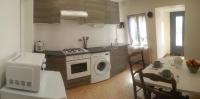 a kitchen with a stove and a washing machine at Gîte du Mas Arnaud in Thuir