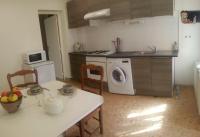 a kitchen with a table and a washing machine at Gîte du Mas Arnaud in Thuir