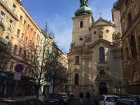 a church with a steeple on the side of a street at Residence St Havel Prague Old Town in Prague