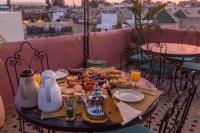 einen Tisch mit Speisen auf dem Balkon in der Unterkunft Riad Hala in Fès