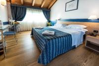 Una habitación de hotel con una cama grande y una mesa. en West Point Airport Hotel, en Dossobuono