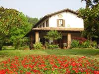 a house with red flowers in front of it at B&amp;B Soiano Del Lago in Soiano del Lago