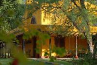 an orange building with trees in front of it at Finca La Encantada in San Rafael