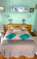 a bedroom with a large bed with two blue lamps at la maison d&#39;idylle in Combourg