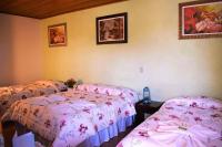 two beds in a room with pink sheets at Pousada Sino dos Ventos in Campos do Jordão