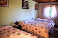 a bedroom with two beds and a window at Pousada Sino dos Ventos in Campos do Jordão
