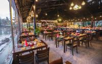 ein Restaurant mit Tischen und Stühlen und Blick aufs Wasser in der Unterkunft Diamond Bay Resort & Spa in Nha Trang