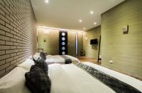 a bedroom with two beds and a brick wall at Ritual and Breakfast in Hualien City
