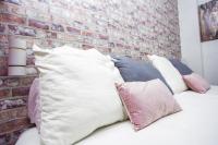 a group of pillows sitting on a bed against a brick wall at Hostal Caminito del Rey in Alora