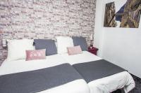 a bedroom with a bed with a brick wall at Hostal Caminito del Rey in Alora