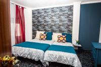 a bedroom with a bed with blue and red at Hostal Caminito del Rey in Alora