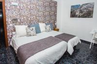 a bedroom with a large bed with a stone wall at Hostal Caminito del Rey in Alora