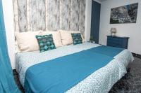 a bedroom with a bed with a blue comforter at Hostal Caminito del Rey in Alora