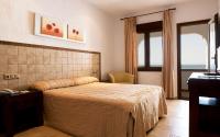 a bedroom with a bed and a table and a window at Hotel Antonio in Zahara de los Atunes