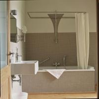 a bathroom with a sink and a tub with a shower at Hotel The Lodge Heverlee in Leuven