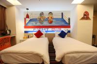 two beds in a room with a boxing game on the wall at Morwing Hotel Fuzhong in Taipei