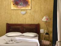 a bedroom with a bed and a lamp and a picture at Hotel Olivier in Três Rios