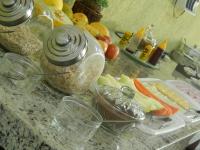 a counter topped with jars of food on a table at Hotel Olivier in Três Rios