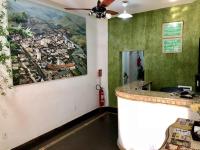 a bar in a restaurant with a painting on the wall at Hotel Olivier in Três Rios