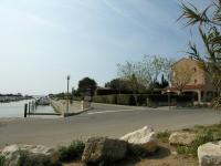 a road next to a body of water with rocks at Studio Mezzanine vue port et mer in La Londe-les-Maures