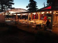 a group of people sitting at tables under a tent at Jabłoń Lake Resort in Pisz