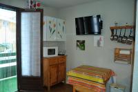 a small room with a bed and a microwave at Résidence les Bords du Lac in Le Lauzet-Ubaye