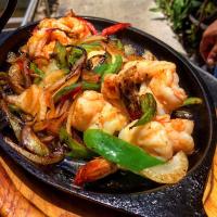 un piatto nero di cibo con gamberetti e peperoni di Blue Angel Resort a Cozumel