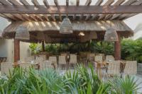 een restaurant met tafels en stoelen onder een pergola bij Mereva Tulum in Tulum