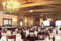 een restaurant met witte tafels en stoelen en een kroonluchter bij Hotel Doña Manuela in Daimiel