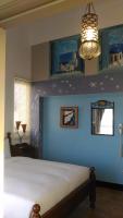 a bedroom with a bed with a blue wall at Alongs Garden in Hengchun South Gate