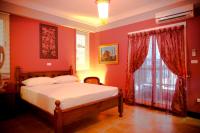 a bedroom with a bed with red walls and a window at Alongs Garden in Hengchun South Gate