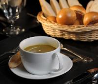 una taza de café en una mesa con una cesta de pan en The Rainforest Ecolodge - Sinharaja with Shuttle Service from Car Park, en Deniyaya