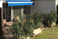 a garden with potted plants in front of a house at Résidence hôtelière A TRAMA in Bonifacio