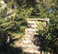 a stone path leading up a hill with trees at Résidence hôtelière A TRAMA in Bonifacio