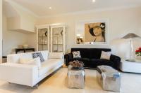 a living room with white furniture and a black couch at Arcos Gardens Sol Rent Golf in Arcos de la Frontera