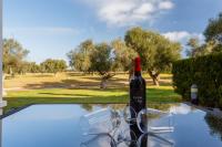 a bottle of wine and glasses sitting on top of a pool at Arcos Gardens Sol Rent Golf in Arcos de la Frontera