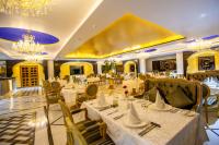 a restaurant with white tables and chairs and chandeliers at Buena Vista Luxury Garden Spa Resort in Jaipur