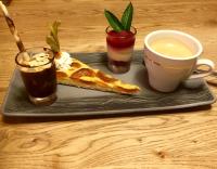 um prato preto com um doce e uma xícara de café em Hôtel Dents de Veisivi em Haudères