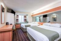 ein Hotelzimmer mit zwei Betten und einem Schreibtisch in der Unterkunft Microtel Inn &amp; Suites by Wyndham Uncasville Casino Area in Uncasville