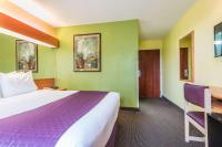 a hotel room with a large bed and a desk at Microtel Inn & Suites by Wyndham Auburn in Auburn