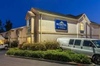 a minivan parked in front of a building with a sign at Microtel Inn & Suites by Wyndham Auburn in Auburn
