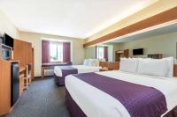 a hotel room with two beds and a flat screen tv at Microtel Inn & Suites by Wyndham Auburn in Auburn
