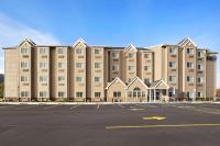 Un gran edificio con un estacionamiento enfrente. en Microtel Inn & Suites-Sayre, PA, en Sayre