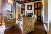 a living room with two chairs and a fireplace at Hacienda el Santiscal in Arcos de la Frontera