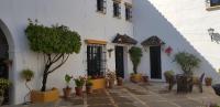 a courtyard with potted plants and a building at Hacienda el Santiscal in Arcos de la Frontera