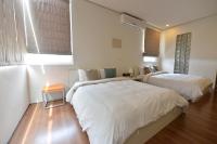 a bedroom with two beds and a window at Penghu Chenhi Bay Homestay in Baisha